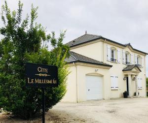 una casa bianca con un cartello davanti di Gîte "Le Millésime 61" a Flavigny