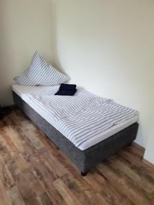 uma cama sentada num piso de madeira num quarto em Herberge-Duisburg-Beeck em Duisburg