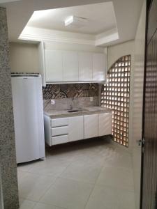 a kitchen with a sink and a white refrigerator at Pipa Mar Hotel in Pipa