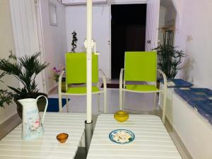 a room with two green chairs and a table at Cosy appart en plein coeur de la Marsa in La Marsa