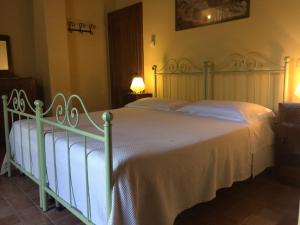 a bedroom with a large bed with white sheets at La Vecchia Camera in Montalcino