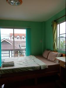a bedroom with a bed and a large window at You&Me Hostel in Chiang Mai