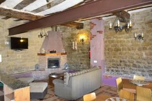 sala de estar con sofá y chimenea en Casa Rural Kandela Etxea, en Lapuebla de Labarca