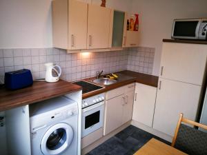 eine Küche mit einer Waschmaschine und einem Waschbecken in der Unterkunft Gäste und Ferienwohnung Gläser Zwickau in Zwickau