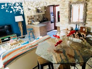 uma cozinha com uma mesa de vidro com peixe vermelho em Le Sitel em Le Brusc