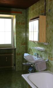 a bathroom with two sinks and a tub and two windows at Appartements Konrad in Söll +17 photos