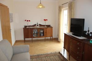 a living room with a couch and a tv on a dresser at VillasFerrel - Cosy Apartment in Ferrel