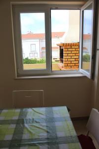 a room with two windows and a view of a building at VillasFerrel - Cosy Apartment in Ferrel