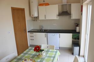 a kitchen with a table with a laptop on it at VillasFerrel - Cosy Apartment in Ferrel