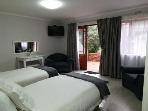una camera d'albergo con due letti e una sedia di Andelomi Nature's Rest a Stormsrivier