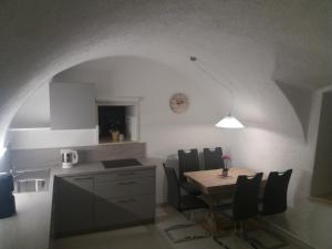 a kitchen and dining room with a table and chairs at Haus Möltner - Apartment "Weinansetz" in Caldaro