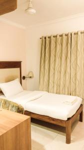 a bedroom with a large bed and a large window at Sai Towers in Puttaparthi