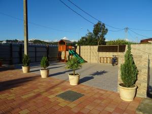 アドレルにあるMimoza Guest Houseのレンガ造りのパティオに鉢植えの植物がある遊び場
