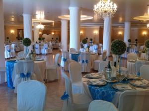 um salão de banquetes com mesas brancas e cadeiras brancas em Hotel Del Sole em Pastorano