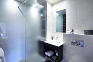 a white bathroom with a sink and a mirror at Hôtel du Golf Saint-Laurent in Ploemel +19 photos