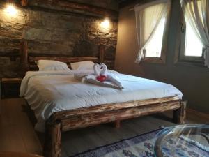 a bedroom with a bed with a stuffed animal on it at Скендерова Къща Къщичка Алиса in Leshten