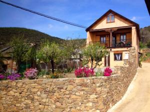 a stone retaining wall in front of a house at El Mirador del Bierzo in Tejedo