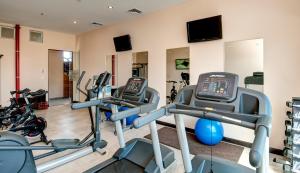 a gym with two treadmills and cardio machines at Studio Hotel Boutique in San José