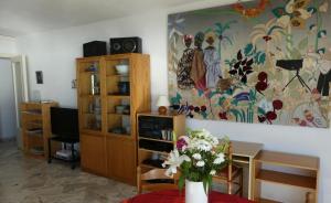 uma sala de estar com um vaso de flores sobre uma mesa em Apartment Montmorency em Cannes