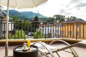 a balcony with a chair and an umbrella at Hotel Villa Boyana - Free Parking in Sofia