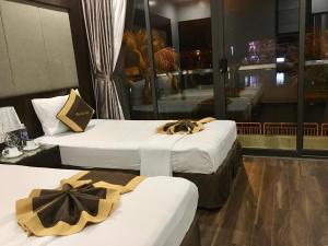 duas camas num quarto de hotel com arcos em Moc Tra Hotel Tuan Chau Hạ Long em Ha Long