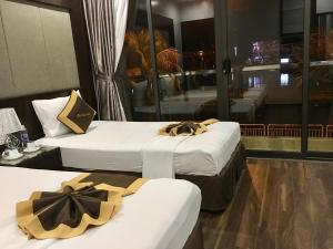 two beds in a hotel room with bows on them at Moc Tra Hotel Tuan Chau Hạ Long in Ha Long