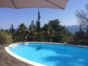 une grande piscine bleue avec un parasol dans l'établissement Rayol-Canadel, à Rayol-Canadel-sur-Mer