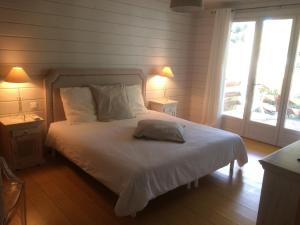 a bedroom with a bed with white sheets and two lamps at Rayol-Canadel in Rayol-Canadel-sur-Mer
