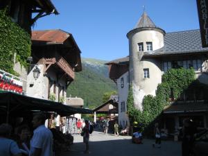 a building with a tower in the middle of a street at Samoëns Apartment 2 bedroom 50m2 modern and well equipt in Samoëns