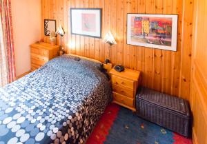 サモエンヌにあるSamoensAlpineHolidayの木製の壁のベッドルーム1室(ベッド1台付)