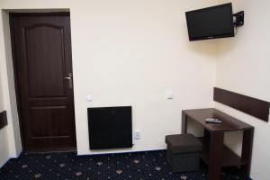 a room with a door and a desk and a television at Faraon Hotel in Ivano-Frankivsk