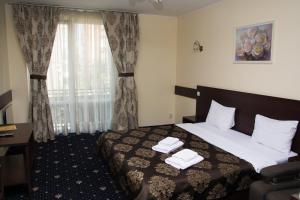 a hotel room with a bed and a window at Faraon Hotel in Ivano-Frankivsk