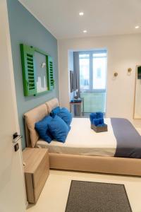 sypialnia z dużym łóżkiem z niebieskimi poduszkami w obiekcie B&B Mareè Seafront Molfetta w mieście Molfetta