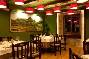 a dining room with tables and chairs and lights at Hotel Cardenal Ram in Morella