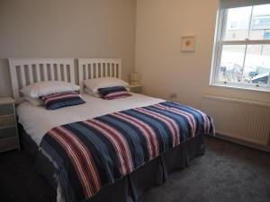 a bedroom with a bed with two pillows and a window at The Old Legion in Eyemouth