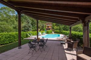 a patio with a table and chairs and a swimming pool at Villa Valdarecchia in Apecchio