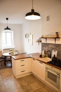 a kitchen with white cabinets and a table in it at CityBrejk Hubska Wrocław in Wrocław