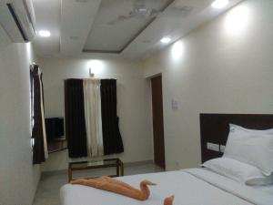 1 dormitorio con 1 cama y 1 vela en el techo en Sri Nivas Guest House, en Mayiladuthurai
