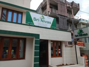 un edificio con un cartel en el costado en Sri Nivas Guest House, en Mayiladuthurai