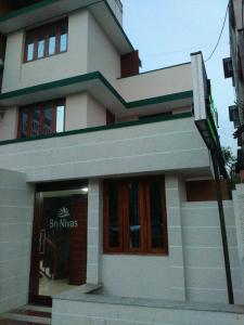 un edificio con una señal delante de él en Sri Nivas Guest House, en Mayiladuthurai