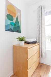 a room with a wooden dresser and a painting on the wall at Annandale Street Quiet Central Family Apartment with Parking in Edinburgh