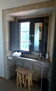 a bathroom sink with a mirror and a wooden stool at Blanco Apartamentos Turísticos in Santiago de Compostela +70 photos