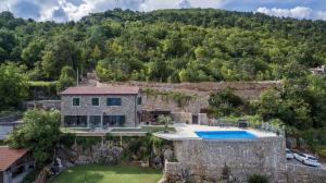 an aerial view of a stone house with a swimming pool at Villa Visum in Poljane