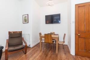 a dining room with a table and chairs and a tv at Old Town Edinburgh Apartment close to Castle and Royal Mile in Edinburgh