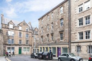 a row of buildings with cars parked in front of them at Old Town Edinburgh Apartment close to Castle and Royal Mile in Edinburgh