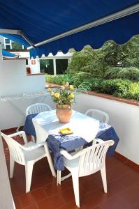 stół i krzesła z wazonem kwiatów na patio w obiekcie Hotel Seven Residence w mieście Palinuro