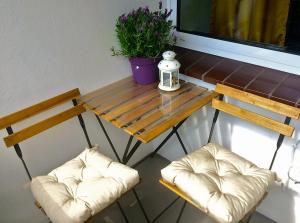 twee stoelen en een houten tafel met een plant erop bij Charmant Wohnen in Duisburg