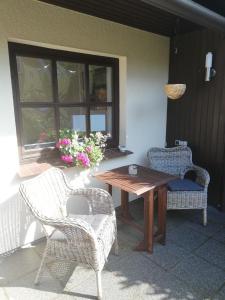 une table et des chaises sur une terrasse avec une fenêtre dans l'établissement Seepferdchen, à Zingst