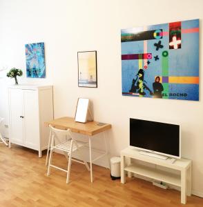 a living room with a desk and a tv at Downtown Apartment Berlin Friedrichshain in Berlin
