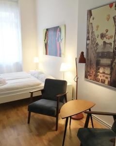 a bedroom with a bed and a chair and a table at Downtown Apartment Berlin Friedrichshain in Berlin